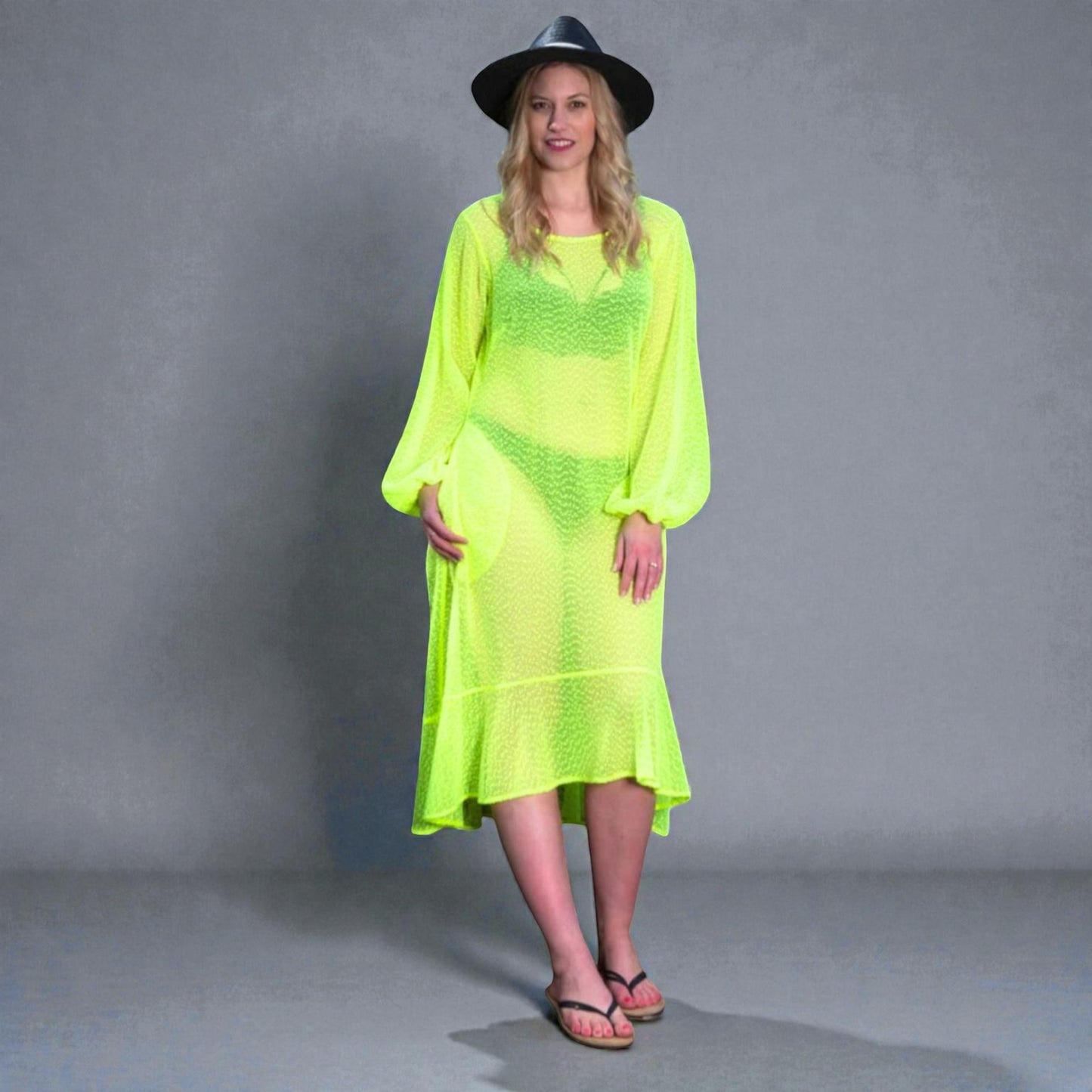 Women's Aphrodite Neon Lime Holiday Resort Dress styled with a bikini underneath, paired with a black hat and black flip-flops for a casual look.