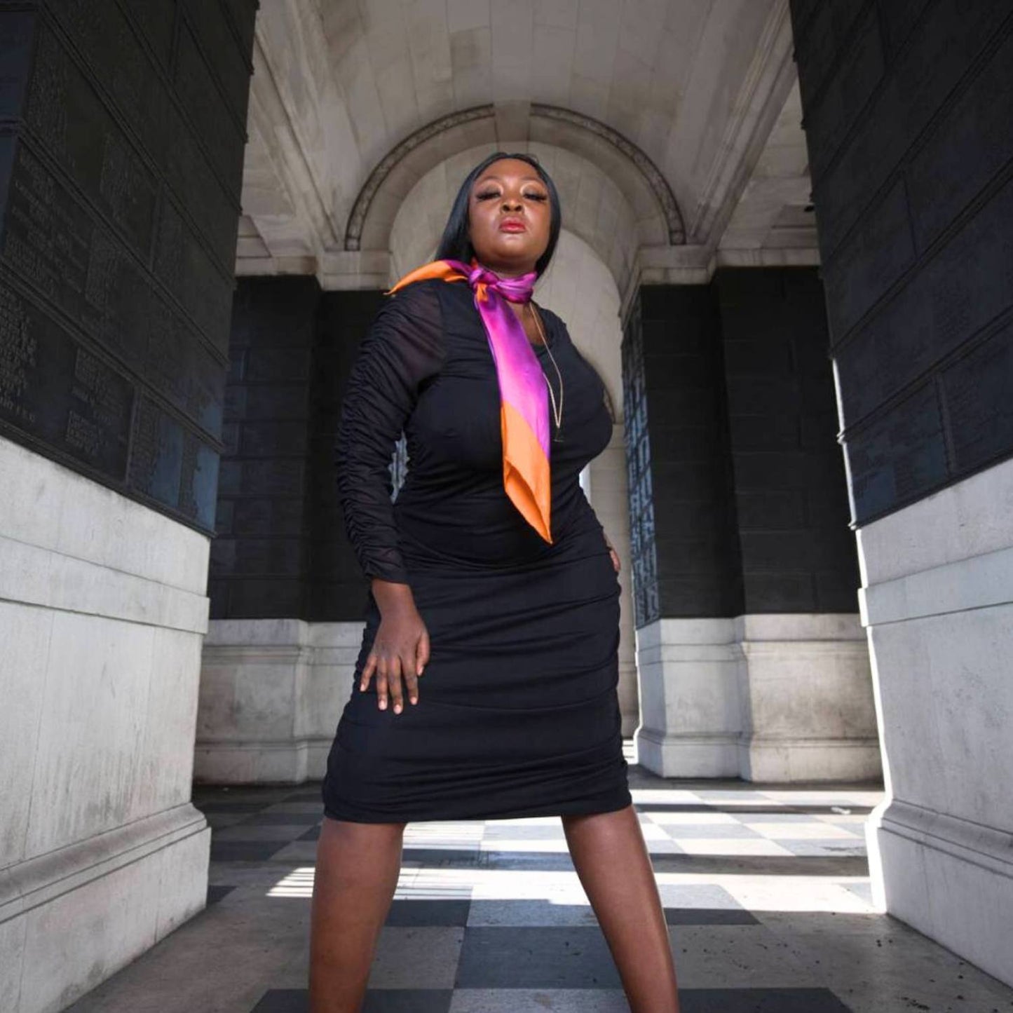 Women's Black Plus Size Boudicca Ruched Bodycon Midi Dress styled with a pink purple silk scarf for a pop of color and an elegant touch.