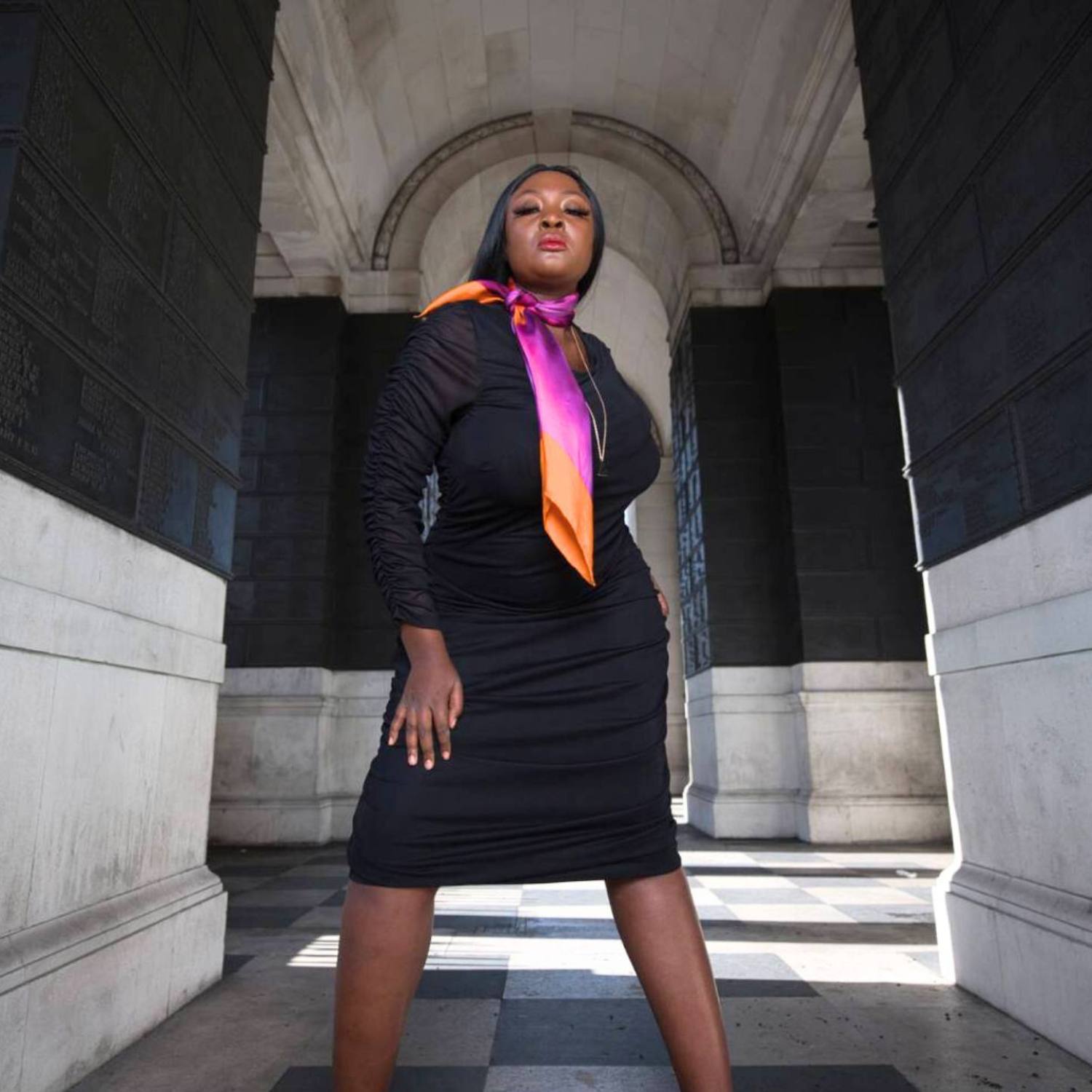 Women's Black Plus Size Boudicca Ruched Bodycon Midi Dress styled with a pink purple silk scarf for a pop of color and an elegant touch.