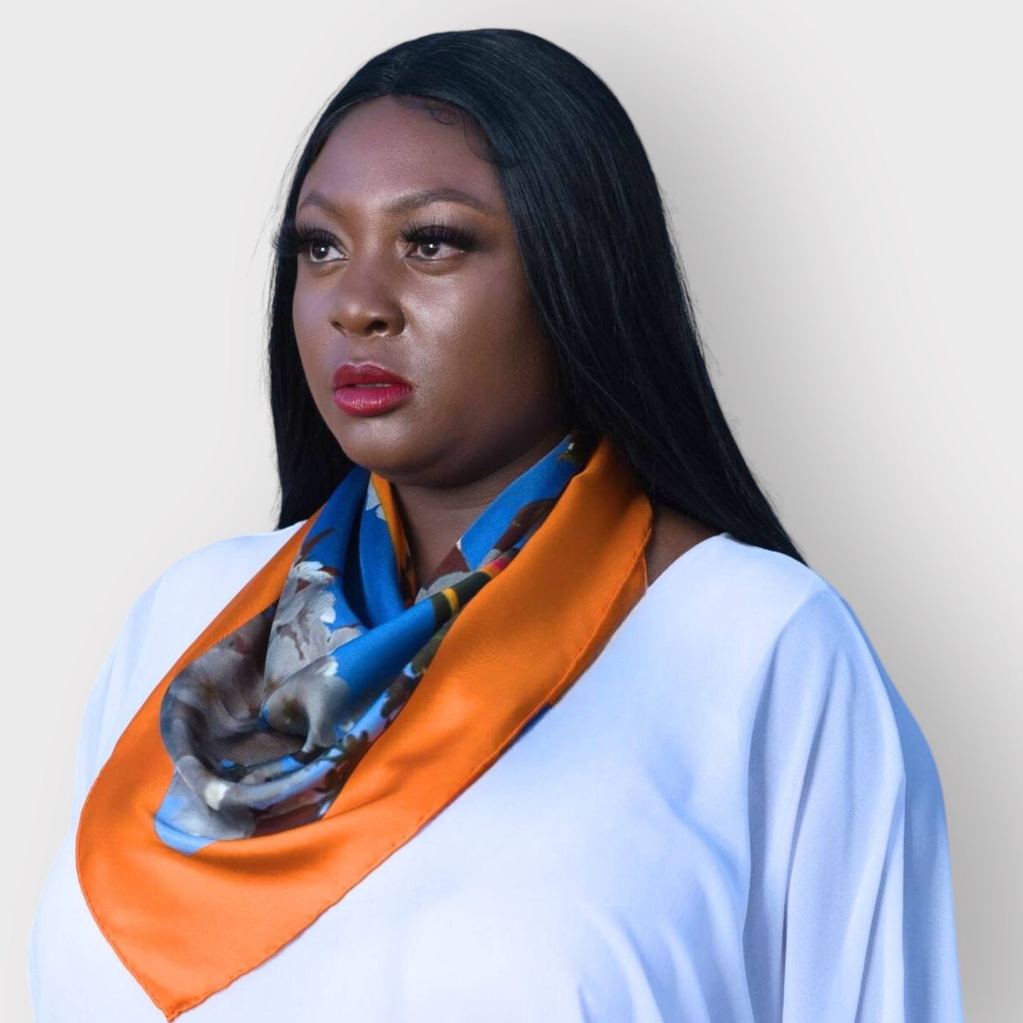 Silk scarf with Orange Bird of Paradise and White Blue Cherry Blossom print, styled around model's neck over a white blouse for a chic look.White Background.