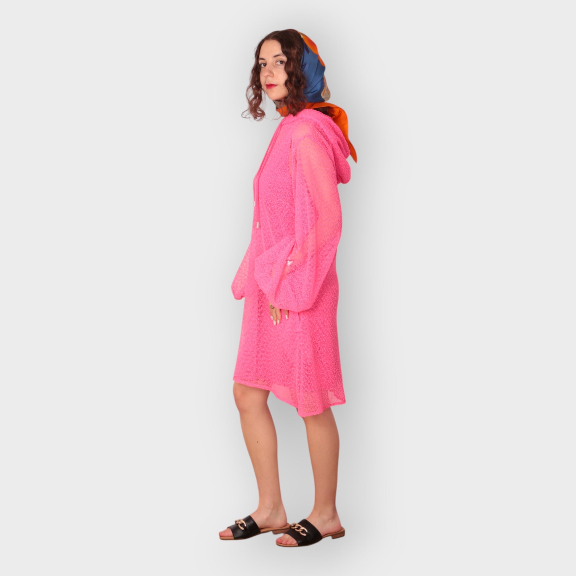 Women is wearing a UK12/ US10  Aphrodite Hot Pink Holiday Resort Dress with matching pink undergarment and hoodie  Short Version photographed from the side.