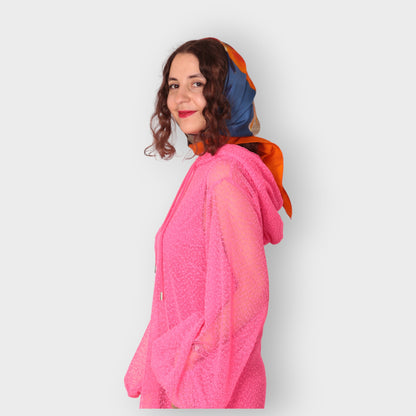 Women is wearing a UK12/ US10  Aphrodite Hot Pink Holiday Resort Dress with matching pink undergarment and hoodie  Short Version photographed from the side. Styled with a headscarf.