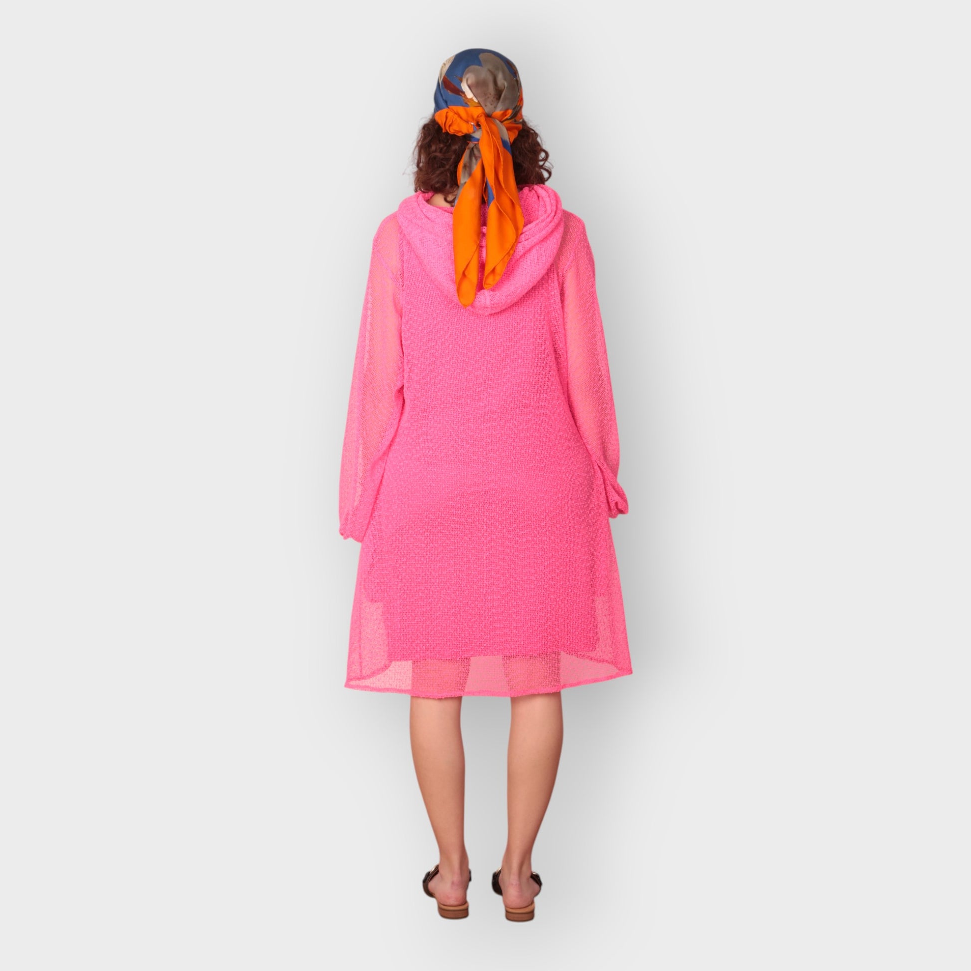 Women is wearing a UK12/ US10  Aphrodite Hot Pink Holiday Resort Dress with matching pink undergarment and hoodie  Short Version photographed from the back.