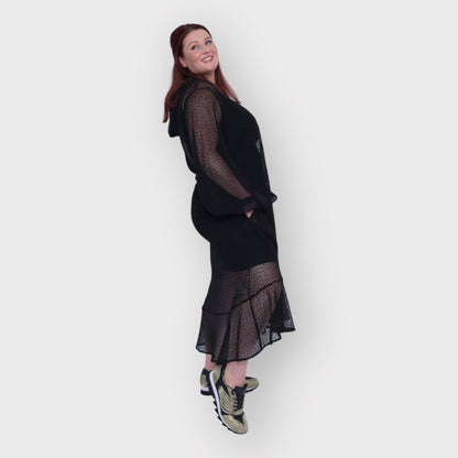 Plus Size Aphrodite Black Holiday Resort Dress with hoodie and black undergarment shown from the side, paired with gold and black sneakers.