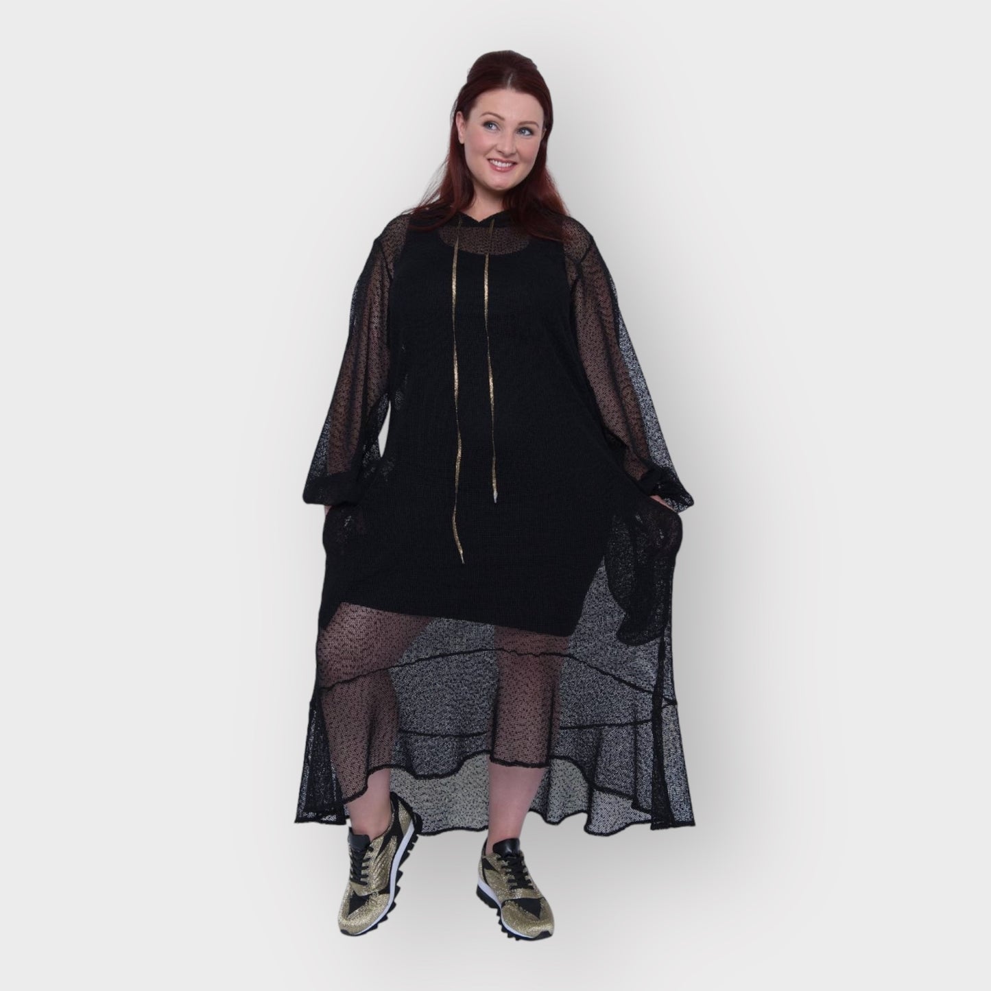 Plus Size Aphrodite Black Holiday Resort Dress with hoodie and black undergarment shown from the front, paired with gold and black sneakers.