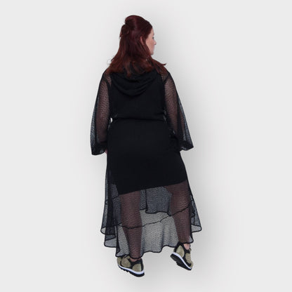 Plus Size Aphrodite Black Holiday Resort Dress with hoodie and black undergarment shown from the back, paired with gold and black sneakers.