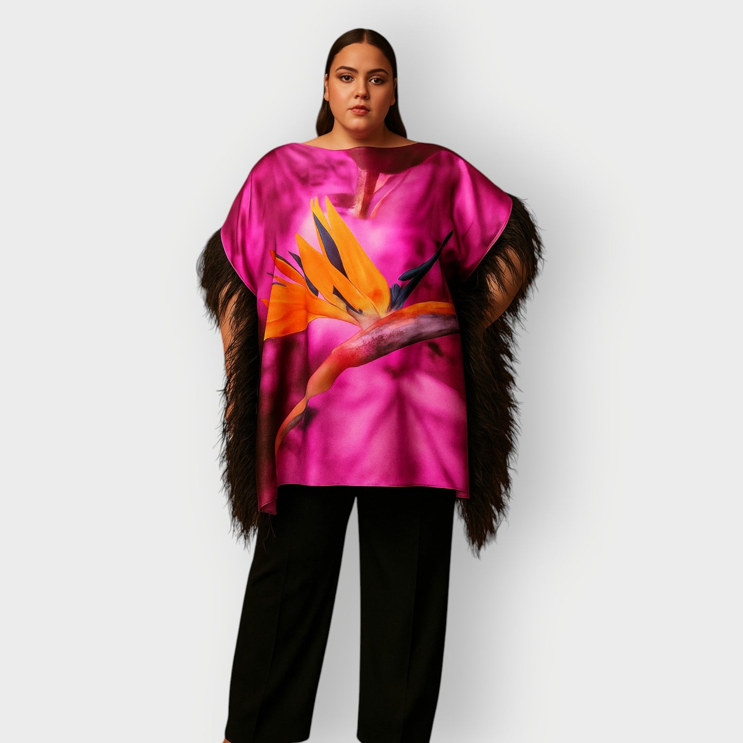 Women wearing a pink purple top with bird of paradise flower design and  black feather trim with black trousers on a white background