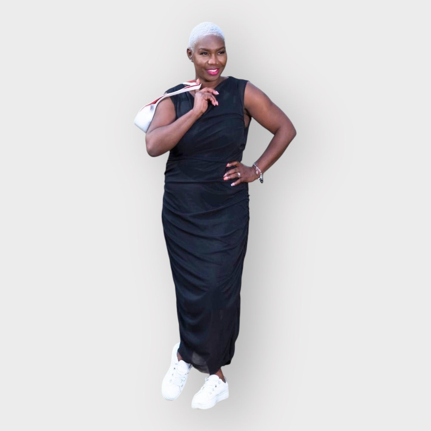 Women's Boudicca Summer Black Ruched Bodycon dress styled with a white handbag and white sneakers for a chic, modern ensemble.