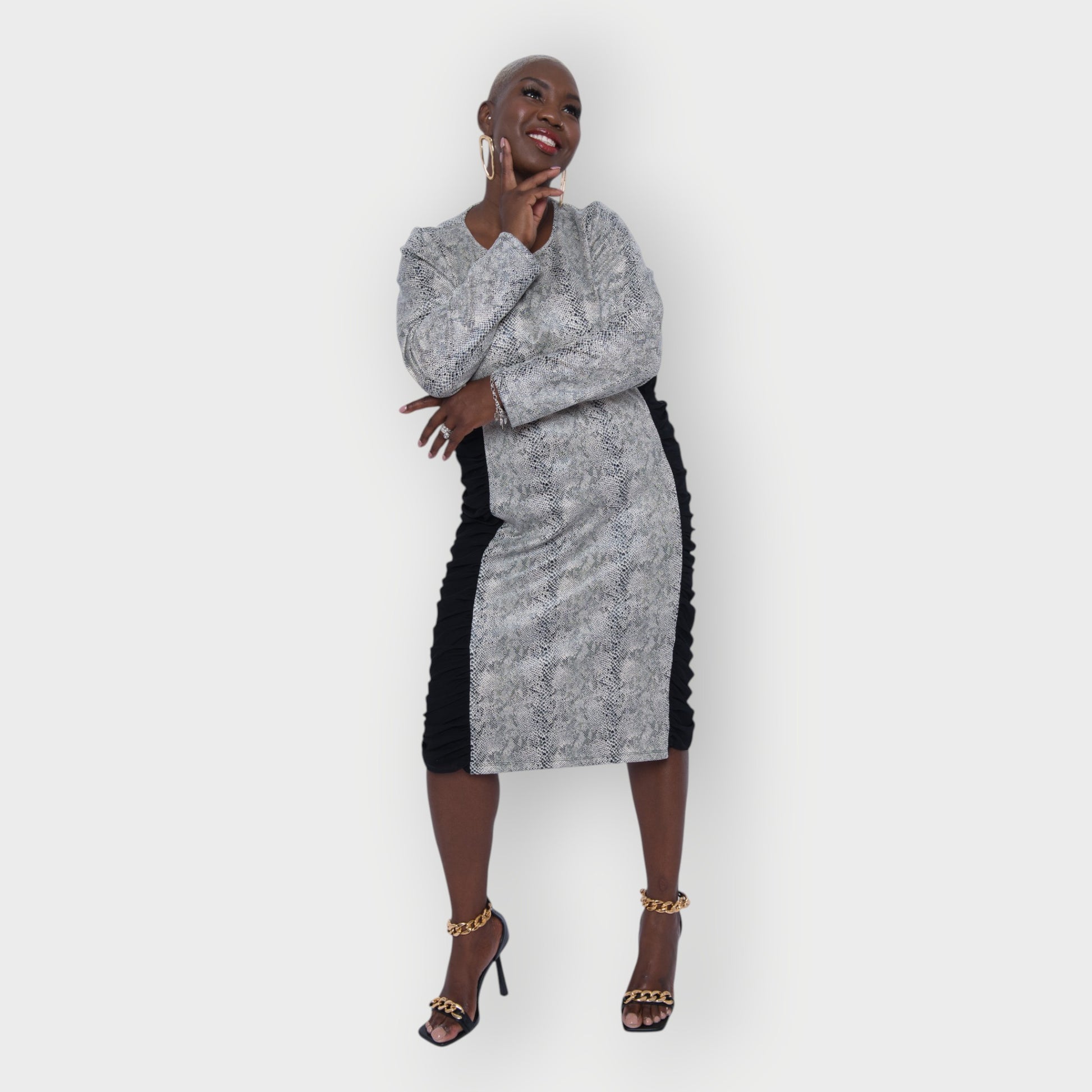 Women's Plus Size Black White Animal Print Bodycon Midi Vegan Leather Dress shown from the front, styled with gold earrings and black heels for a chic look.White Background.