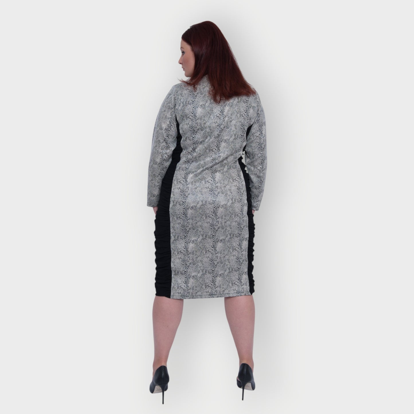 Women's Plus Size Black White Animal Print Bodycon Midi Vegan Leather Dress shown from the back, styled with black heels for a chic look.White Background.