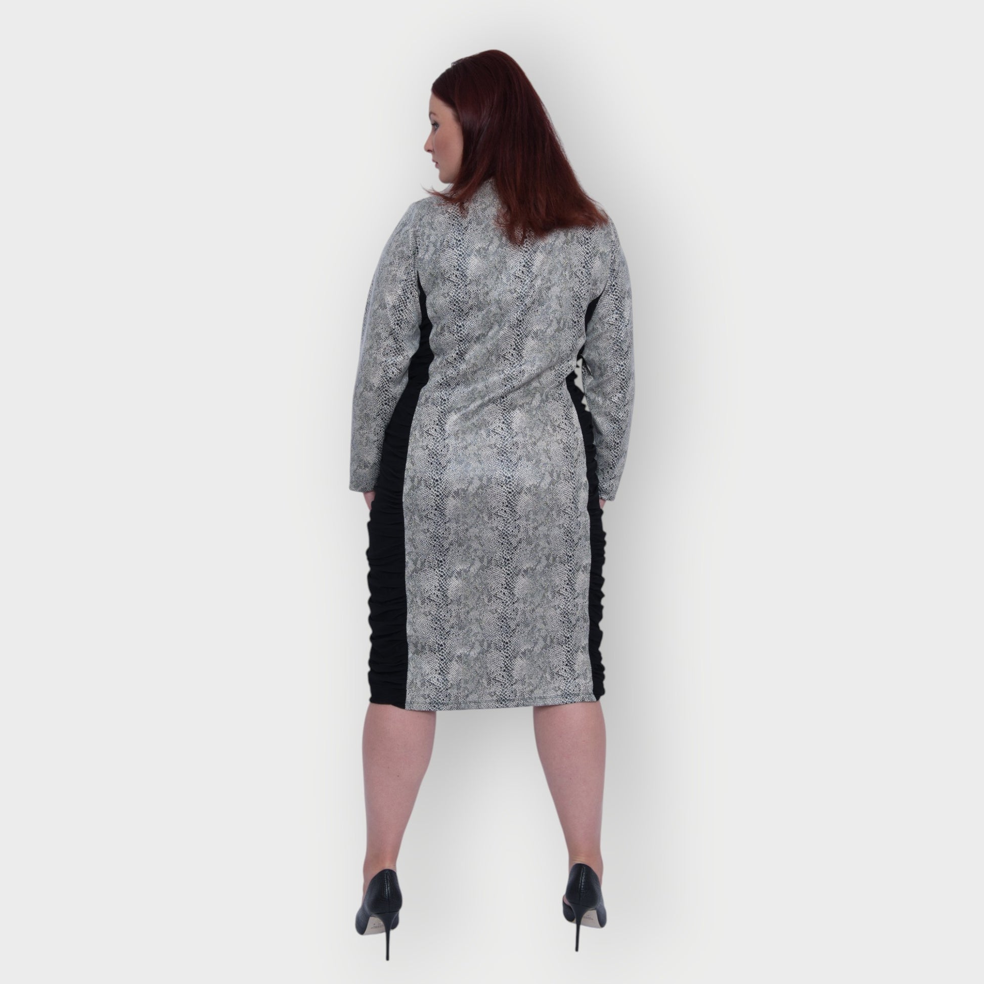 Women's Plus Size Black White Animal Print Bodycon Midi Vegan Leather Dress shown from the back, styled with black heels for a chic look.White Background.