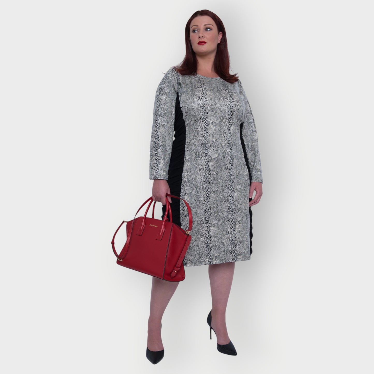 Women's Plus Size Black White Animal Print Bodycon Midi Vegan Leather Dress styled with a red Michael Kors handbag and black heels for an elegant look.