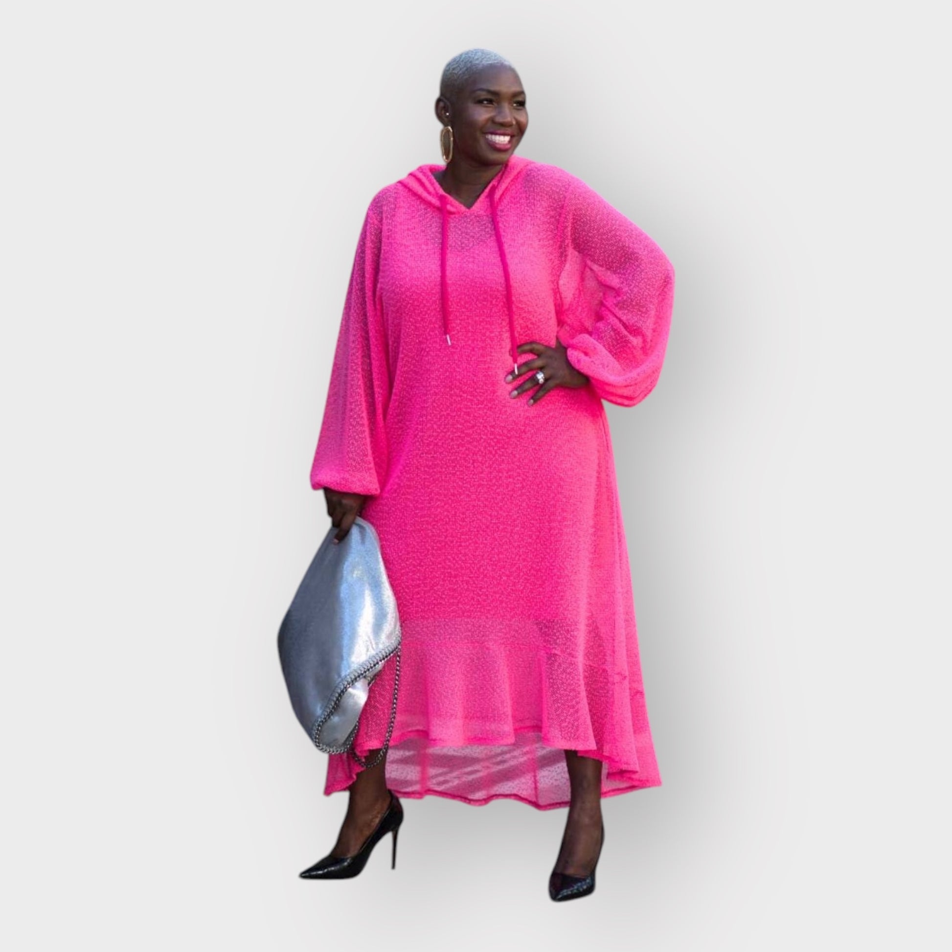 Women's Plus Size Aphrodite Hot Pink Holiday Resort Dress with hoodie and hot pink undergarment, paired with a silver handbag and black heels for a chic beach look.