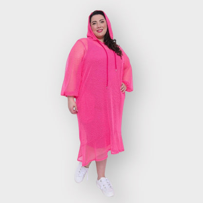 Women's Plus Size Aphrodite Hot Pink Holiday Resort Dress with hoodie and hot pink undergarment, paired with white sneakers for a relaxed look.