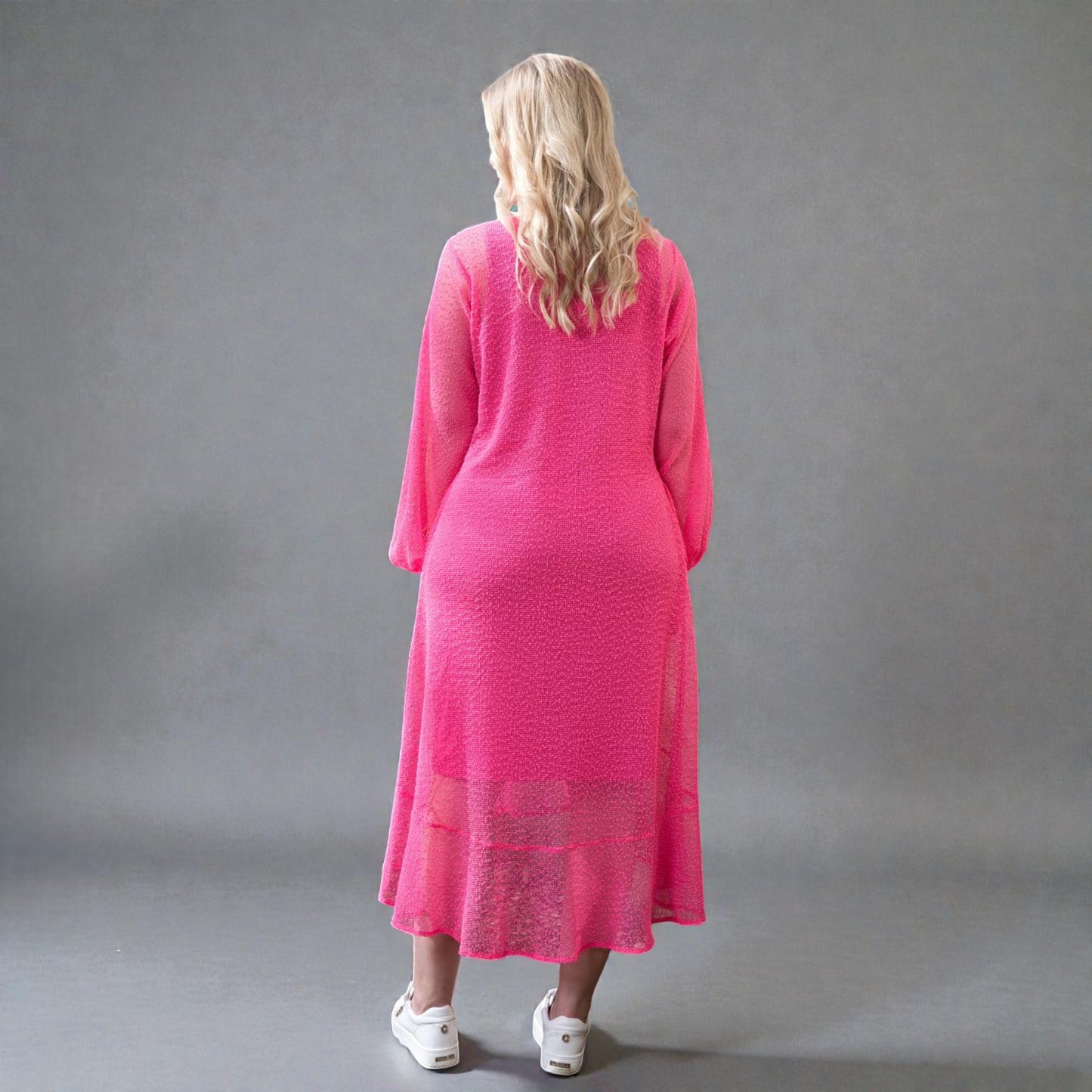 Women's Aphrodite Hot Pink Holiday Resort Dress with a hot pink undergarment shown from the side, paired with white sneakers