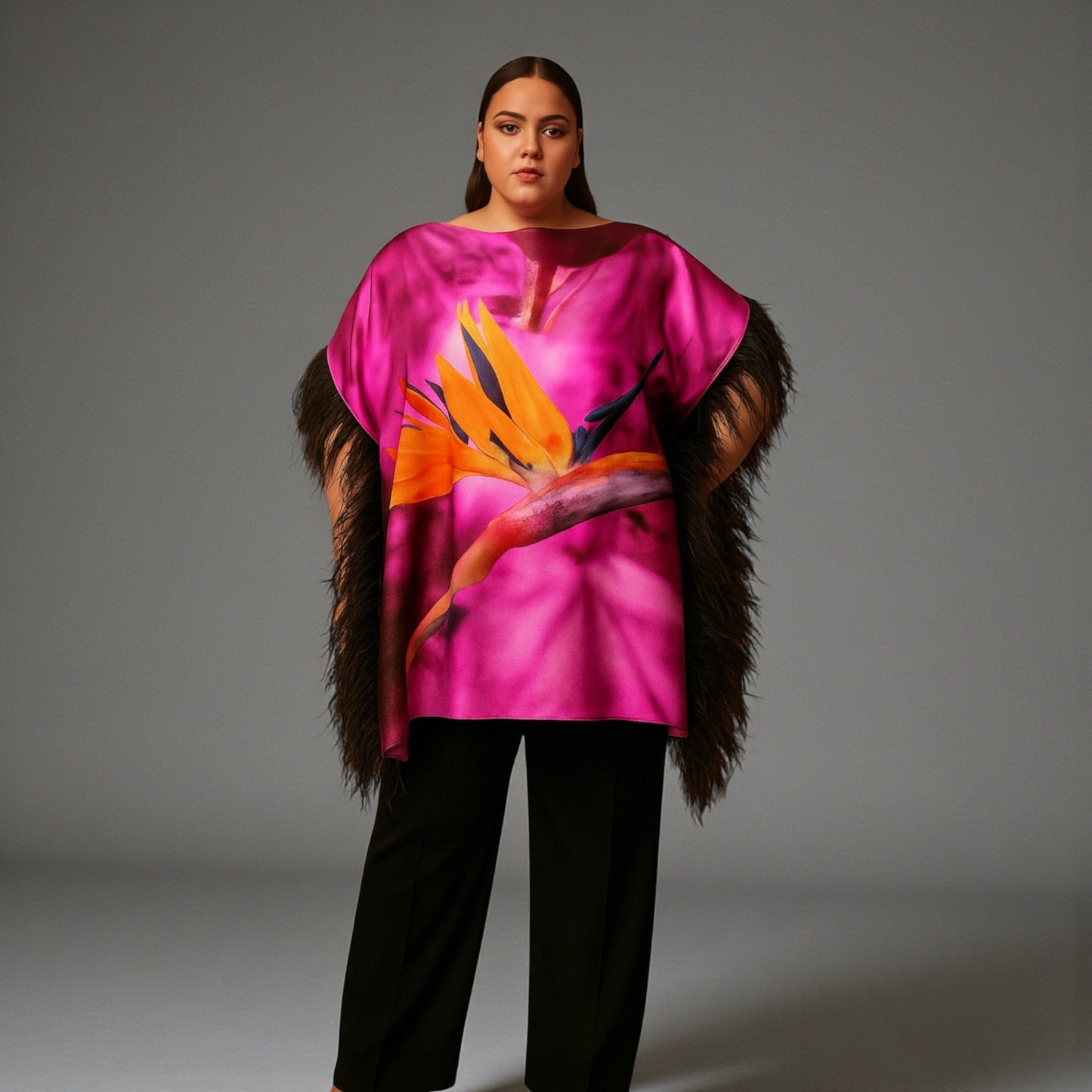 Women wearing a pink purple top with bird of paradise flower design and  black feather trim with black trousers on a plain background