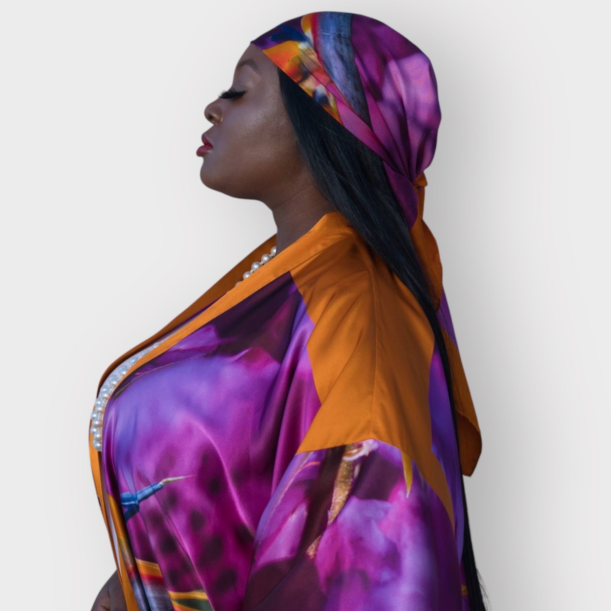 Silk scarf with Orange Bird of Paradise and Pink and Purple print styled as a headscarf, paired with a Pink and Purple Luxury Silk Kimono.White Background.