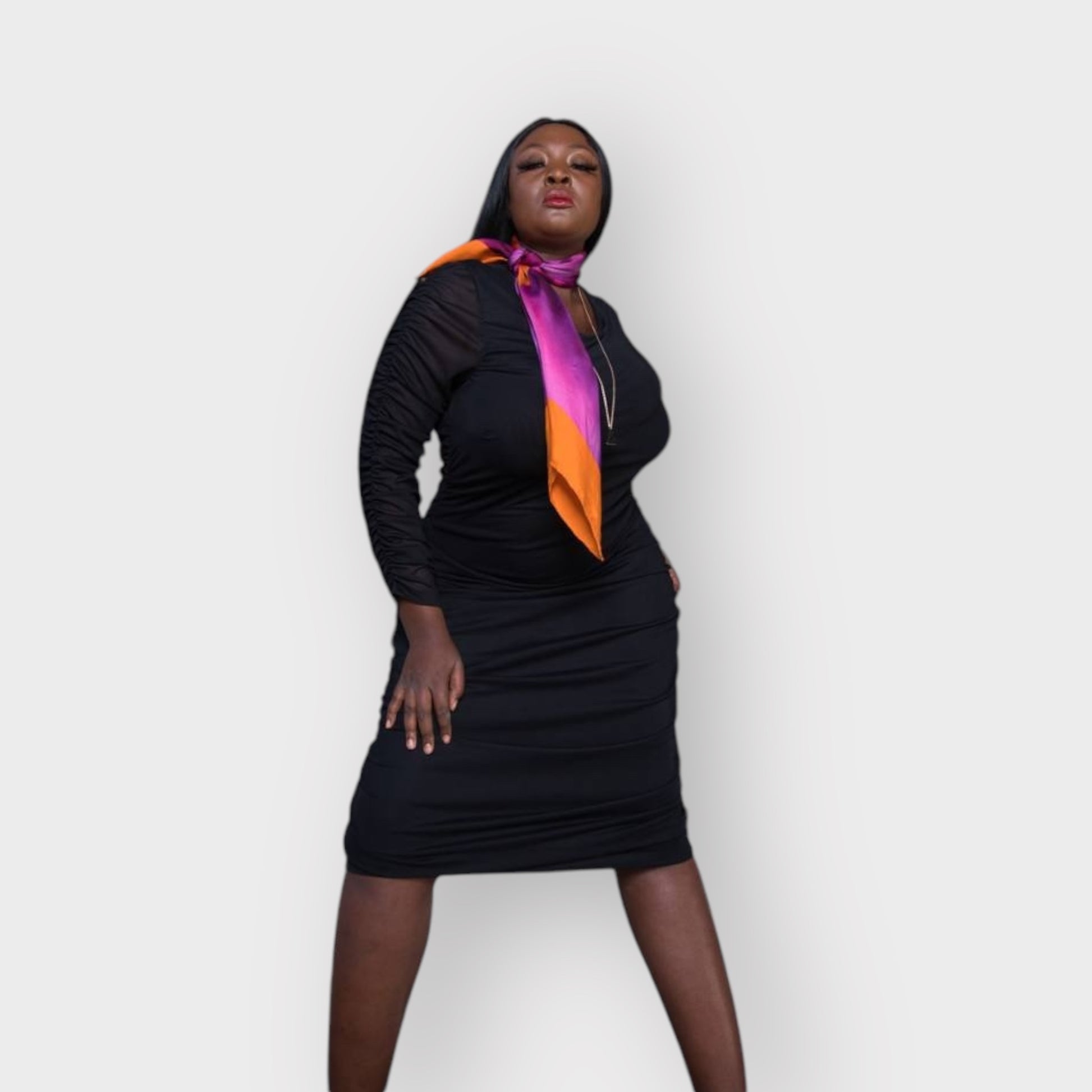 Silk scarf with Orange Bird of Paradise and Pink and Purple print, styled elegantly around model's neck over the Boudicca Black Plus Size Ruched Bodycon Dress.White Background.