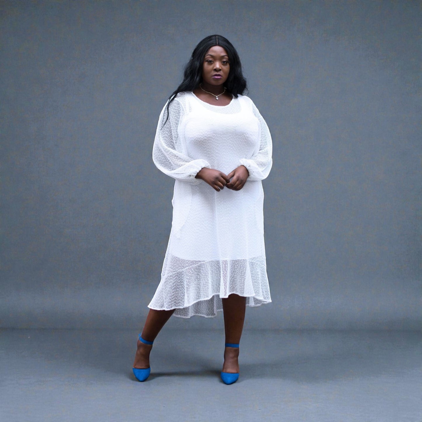 Women's Plus Size Aphrodite White Holiday Resort Dress with a white undergarment, paired with blue heels for a chic urban look