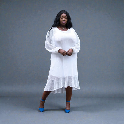 Women's Plus Size Aphrodite White Holiday Resort Dress with a white undergarment, paired with blue heels for a chic urban look