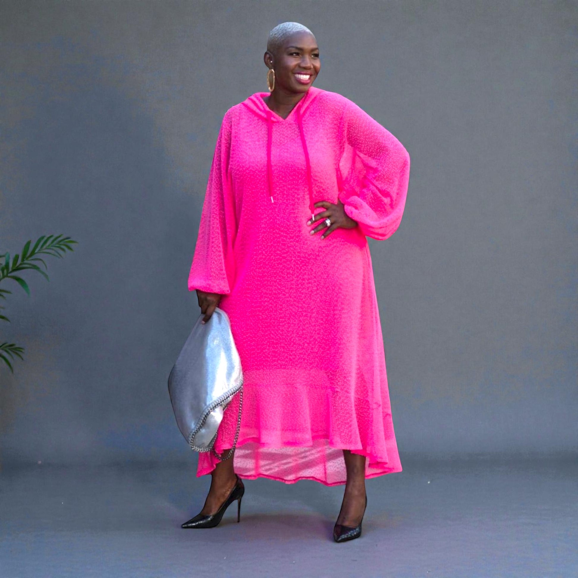 Women's Plus Size Aphrodite Hot Pink Holiday Resort Midi Dress with hoodie and hot pink undergarment, paired with a silver handbag and black heels for a chic look.