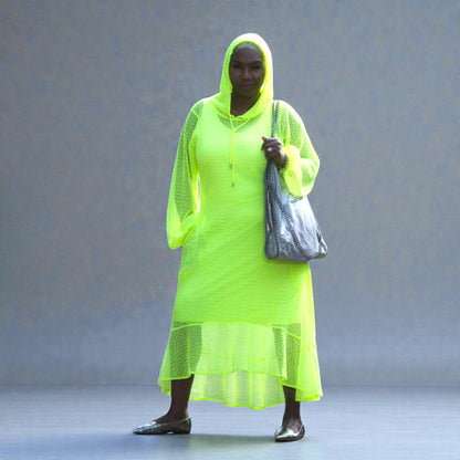 Women's Plus Size Aphrodite Neon Lime Holiday Resort Dress with hoodie and matching neon lime undergarment, styled with a silver  handbag and silver flats.