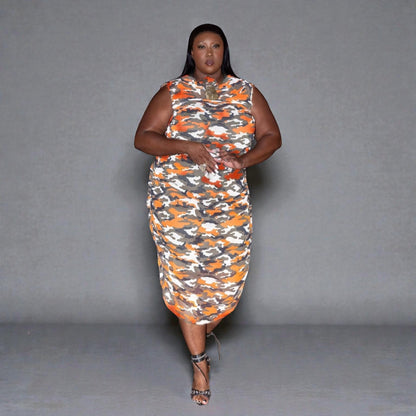 Woman wearing a sleeveless dress with orange and gray pattern on a gray background. Jewellery by Veronique Design.