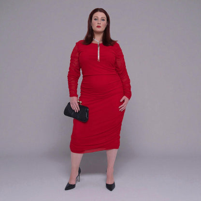 Plus Size Woman wearing a red dress with sheer sleeves against a gray background