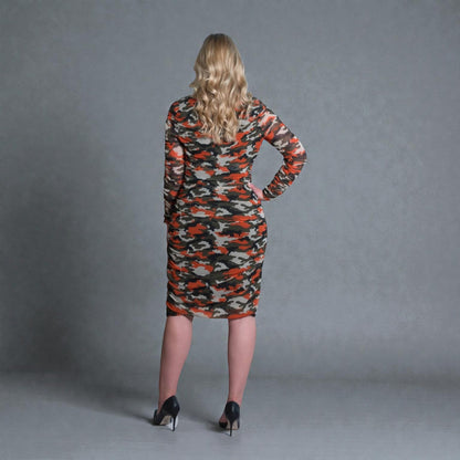 Women's Mid Size Orange Green Grey Camouflage Bodycon Midi Dress styled with  black heels for a modern, stylish look. Plain background.