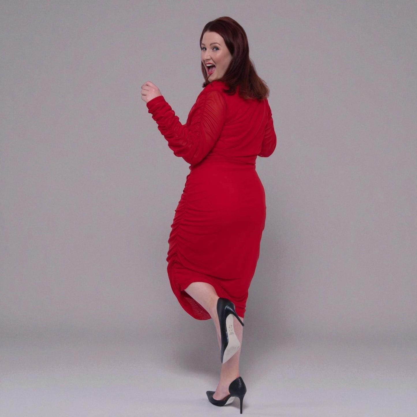 Plus Size Woman in a red dress posing against a plain background