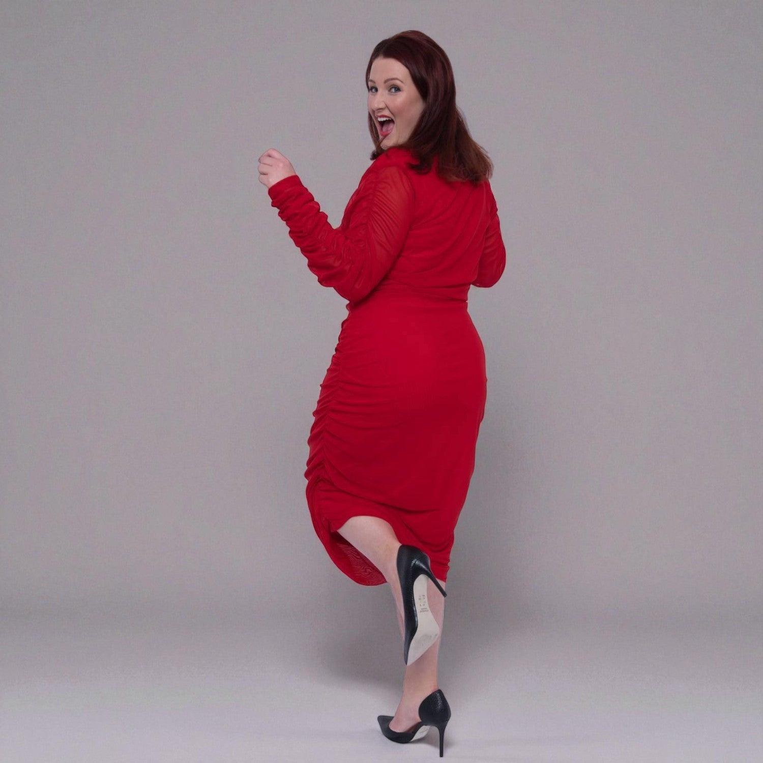 Plus Size Woman in a red dress posing against a plain background