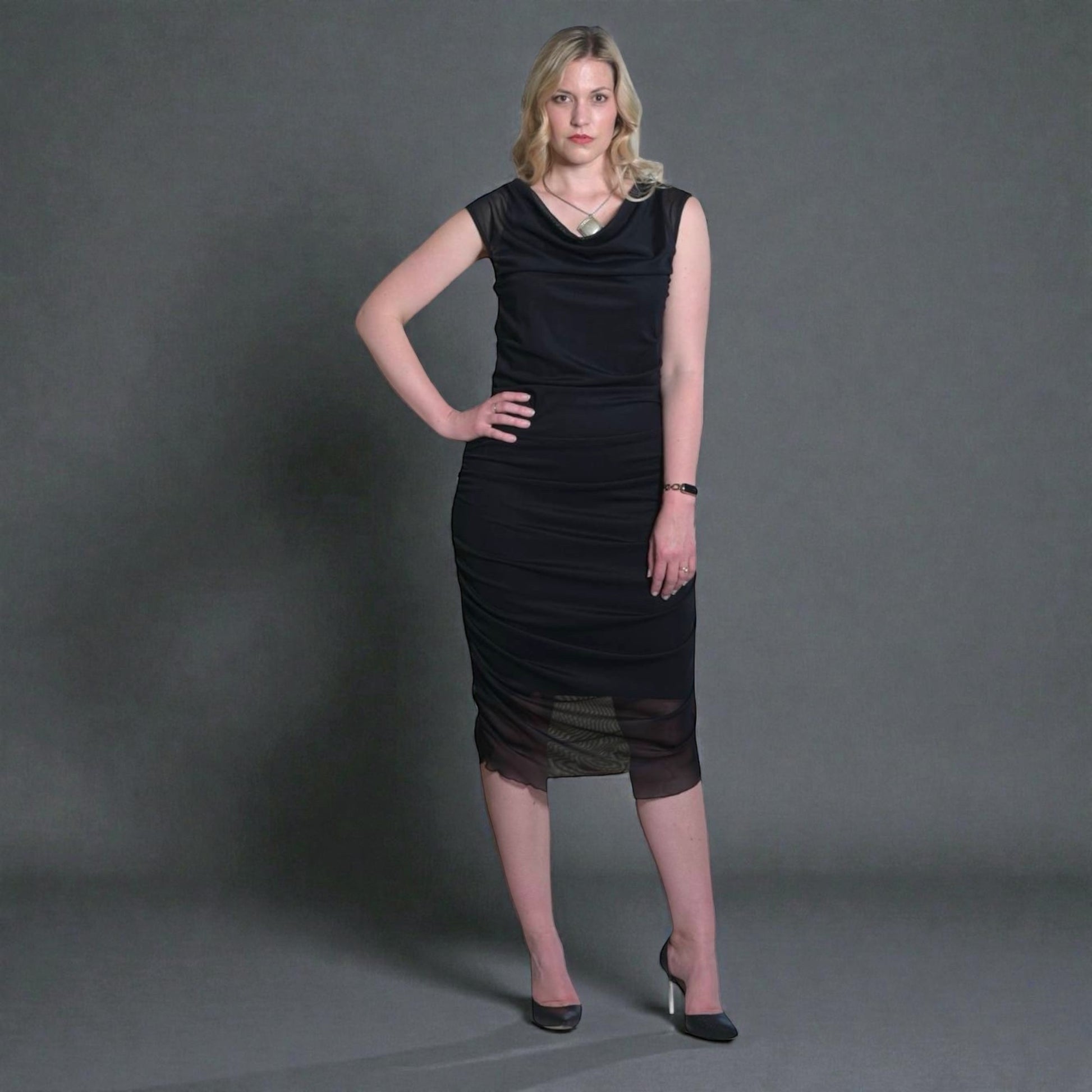 Women's Boudicca Summer Black Ruched Midi Dress styled with a silver necklace and black heels for an elegant, sophisticated look.