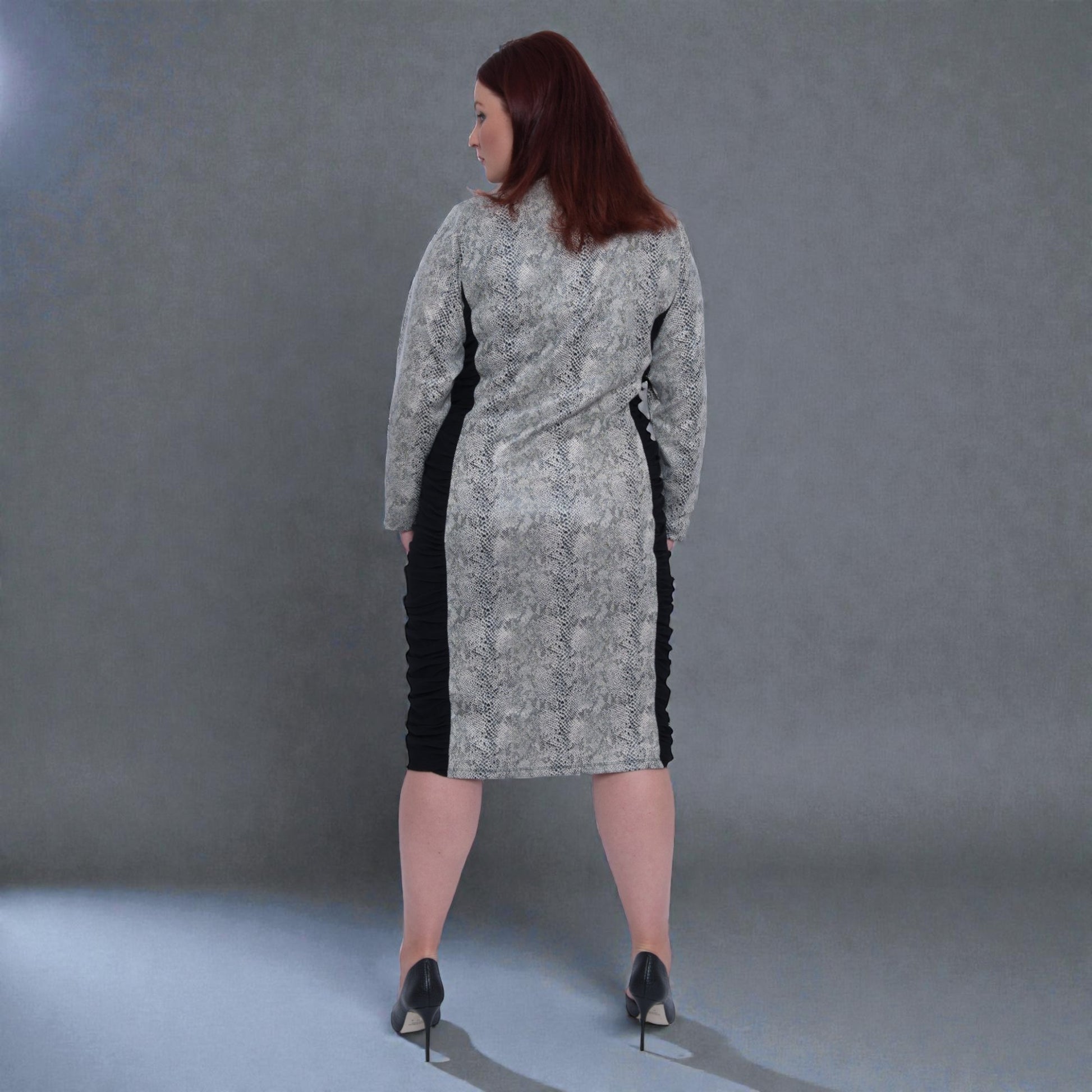 Women's Plus Size Black White Animal Print Bodycon Midi Vegan Leather Dress shown from the back, styled with black heels for a chic look.Grey Background.