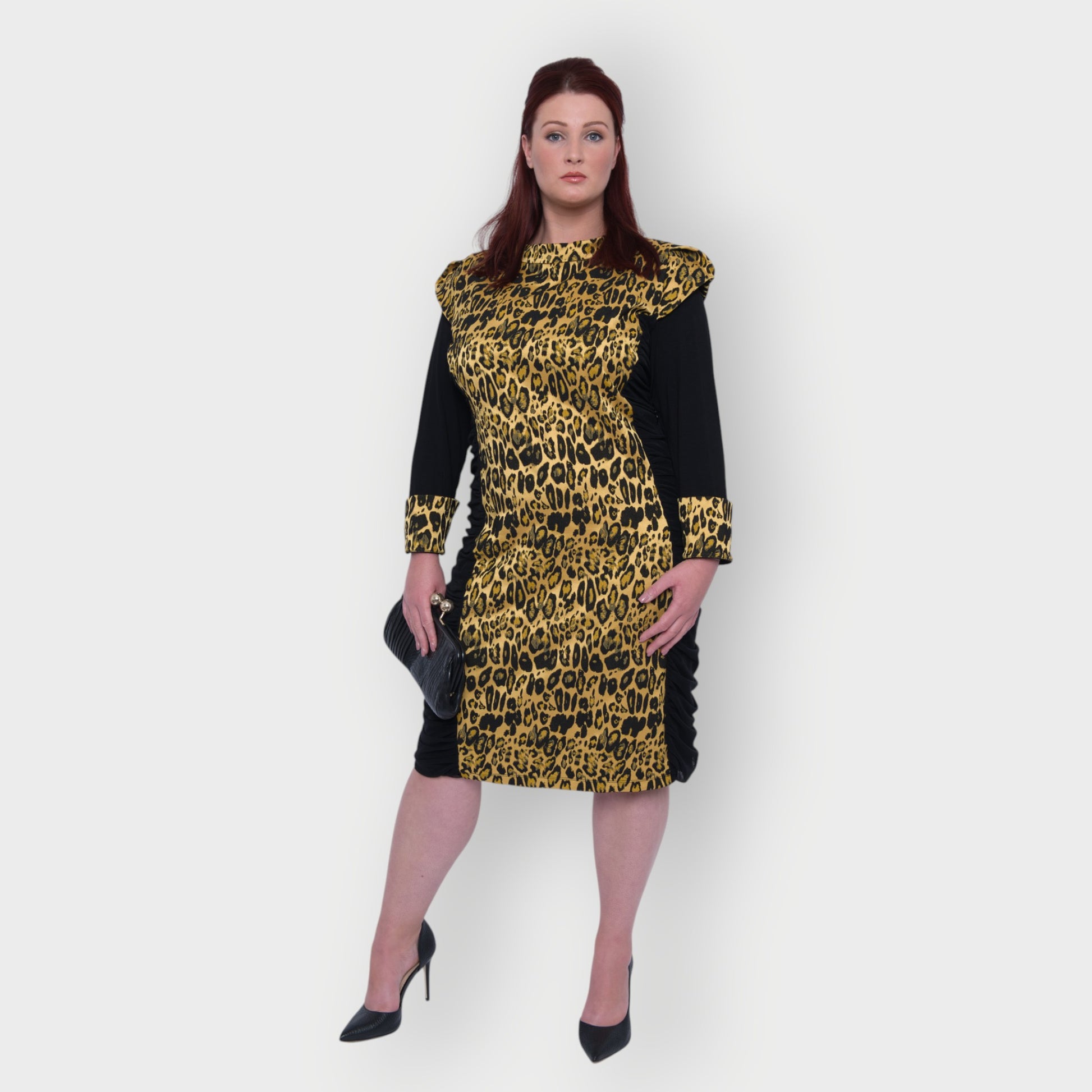 Women's Plus Size Black Gold Bodycon Midi Leopard Brocade Jacquard Dress styled with a black clutch and black heels for an elegant, polished look. White Background.