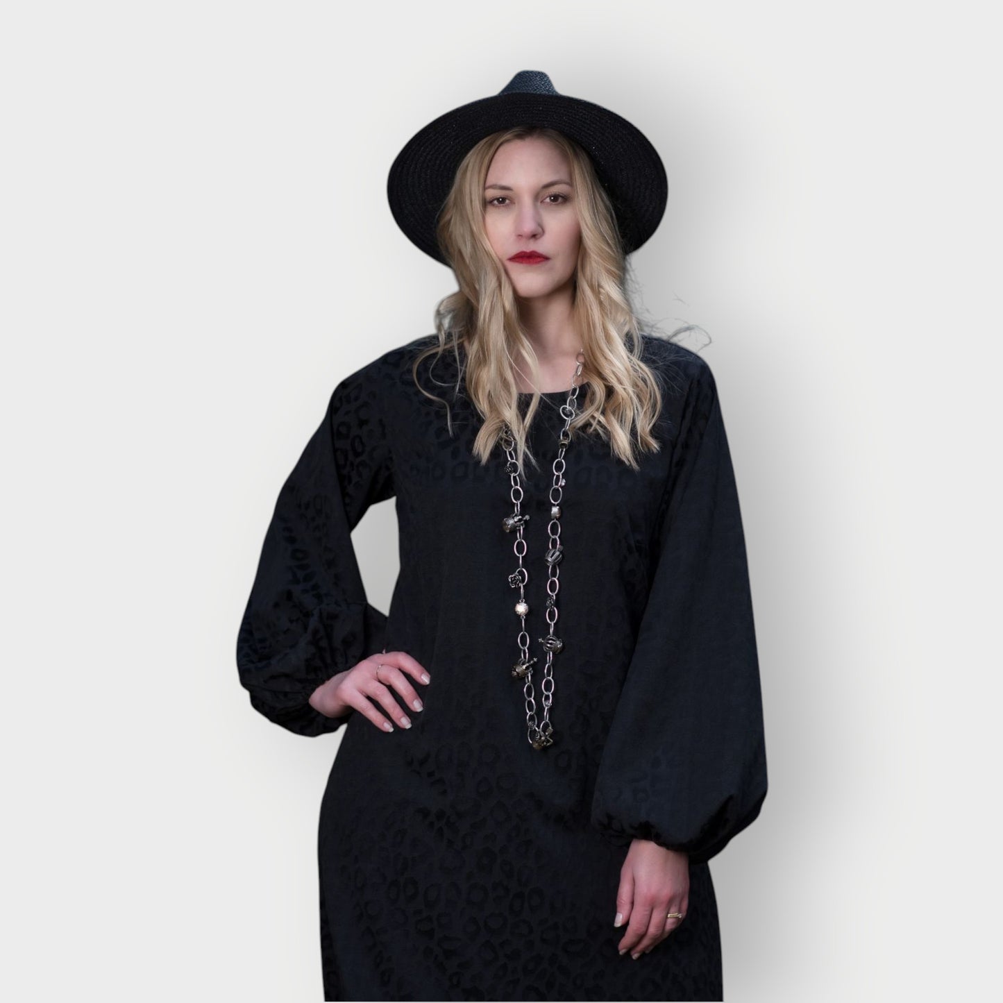 Women's Aphrodite Black Leopard Jacquard Dress close up, styled with a silver chain necklace and black hat for a chic, coordinated look.