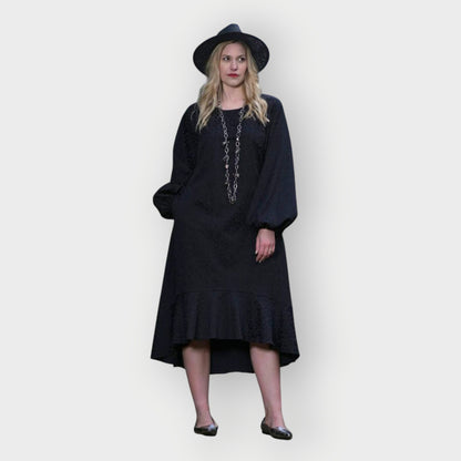 Women's Aphrodite Black Leopard Jacquard Dress styled with a silver chain necklace, black hat, and silver flats for a chic, coordinated look.