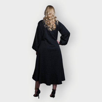 Women's Aphrodite Black Leopard Jacquard Dress styled with gold chain heels for a chic, coordinated look.