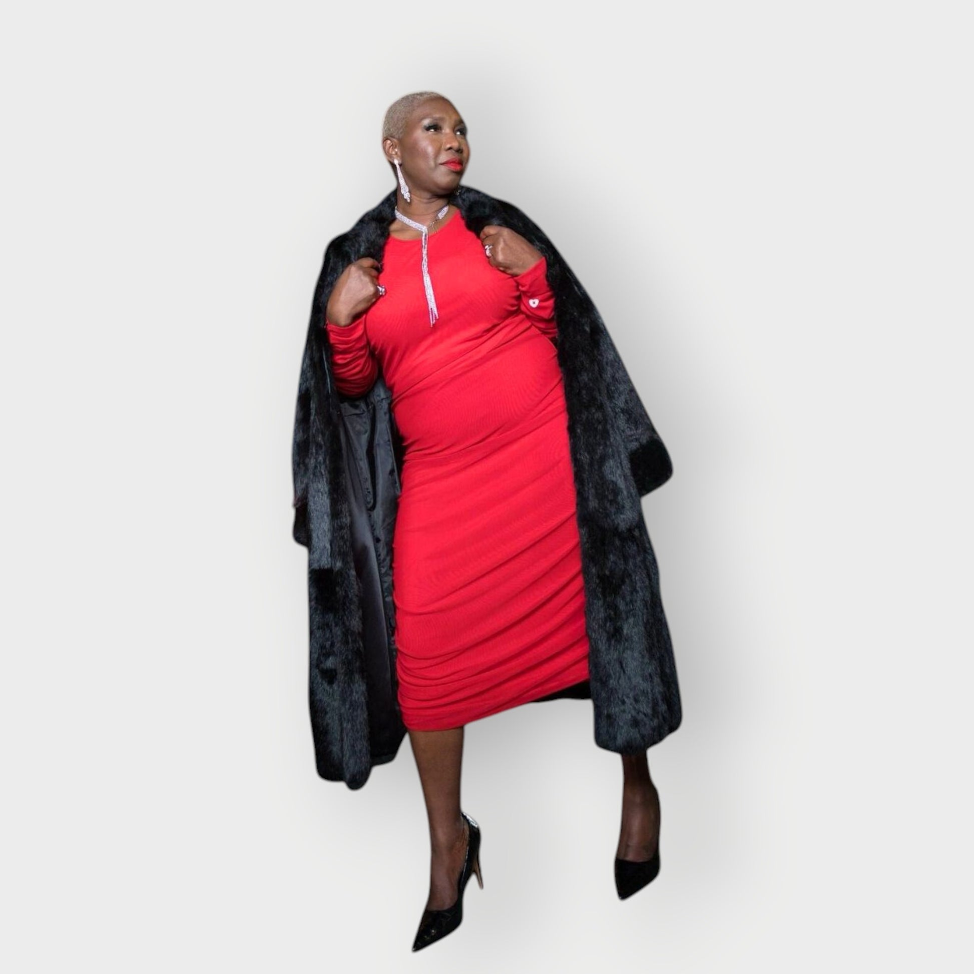 Women's Red Plus Size Boudicca Ruched Bodycon Midi Dress styled with a vintage fur coat and black heels. White Background.