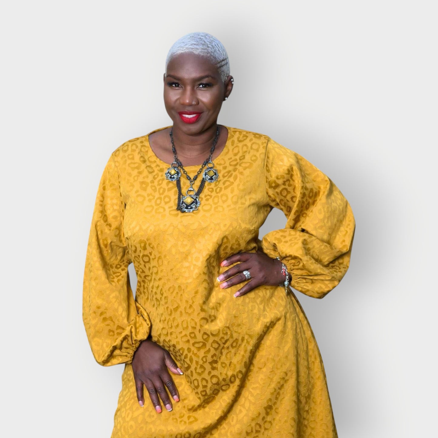 Women's Plus Size Gold Aphrodite Leopard Jacquard Dress shown as a close up, styled with a yellow stone necklace for an elegant look.