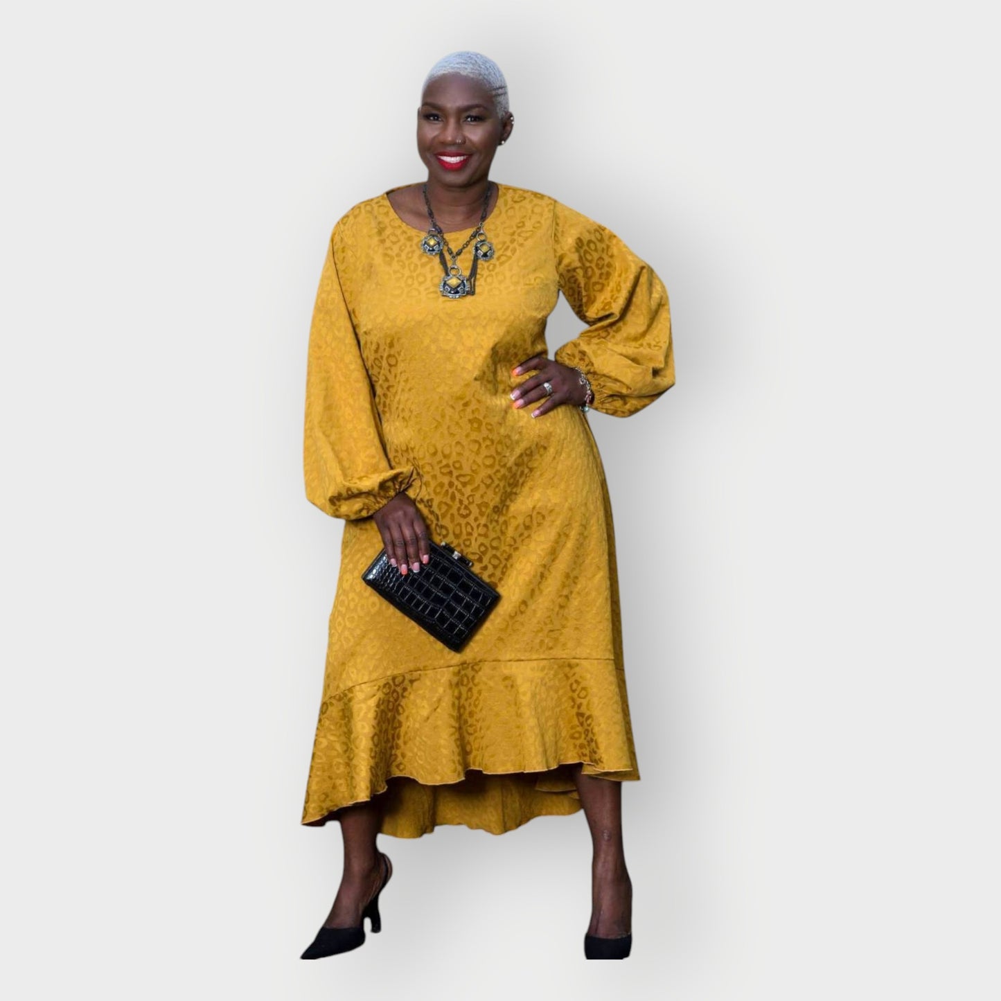 Women's Plus Size Gold Aphrodite Leopard Jacquard Dress styled with a yellow stone necklace, black clutch, and black heels for an elegant look.