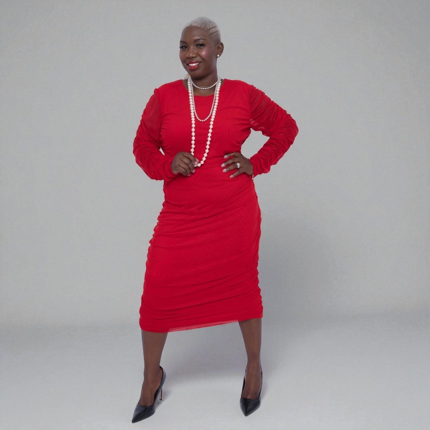 Woman wearing a Boudicca Tomato Red Ruched Midi Dress with a plain background