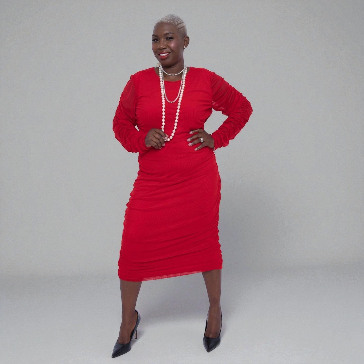 Woman wearing a Boudicca Tomato Red Ruched Midi Dress with a plain background