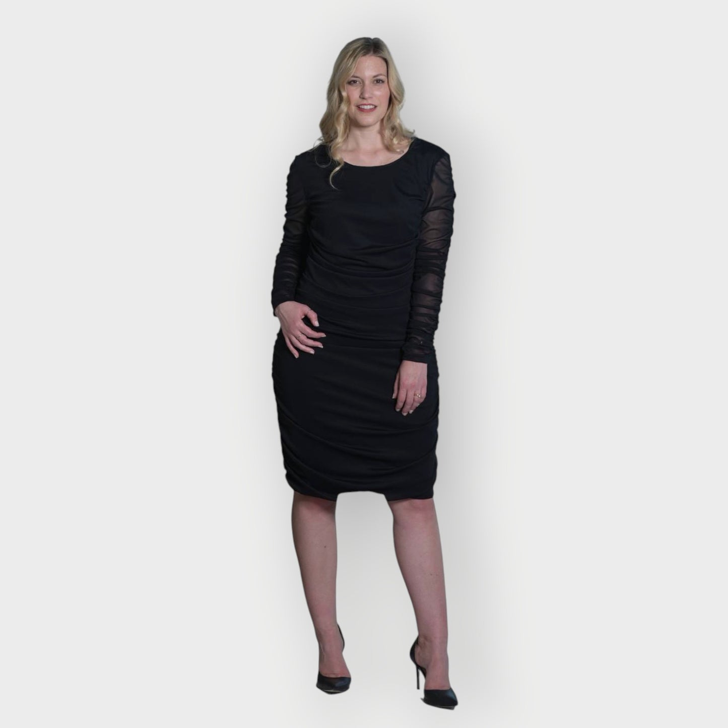 Women's Black Mid Size Ruched Bodycon Midi Dress styled with black heels for a classic and elegant touch.