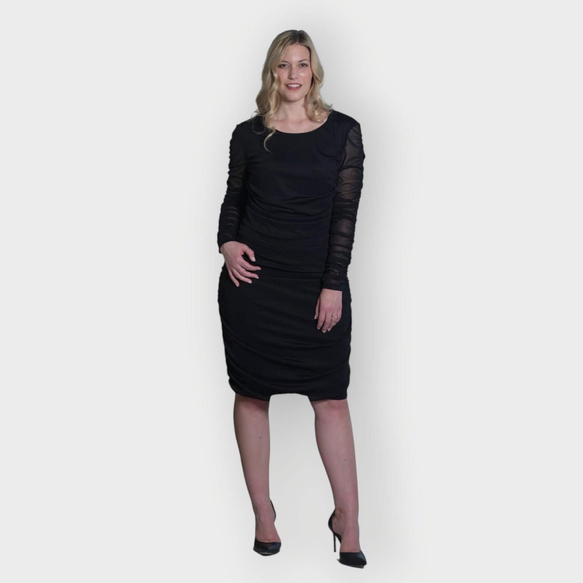 Women's Black Mid Size Ruched Bodycon Midi Dress styled with black heels for a classic and elegant touch.