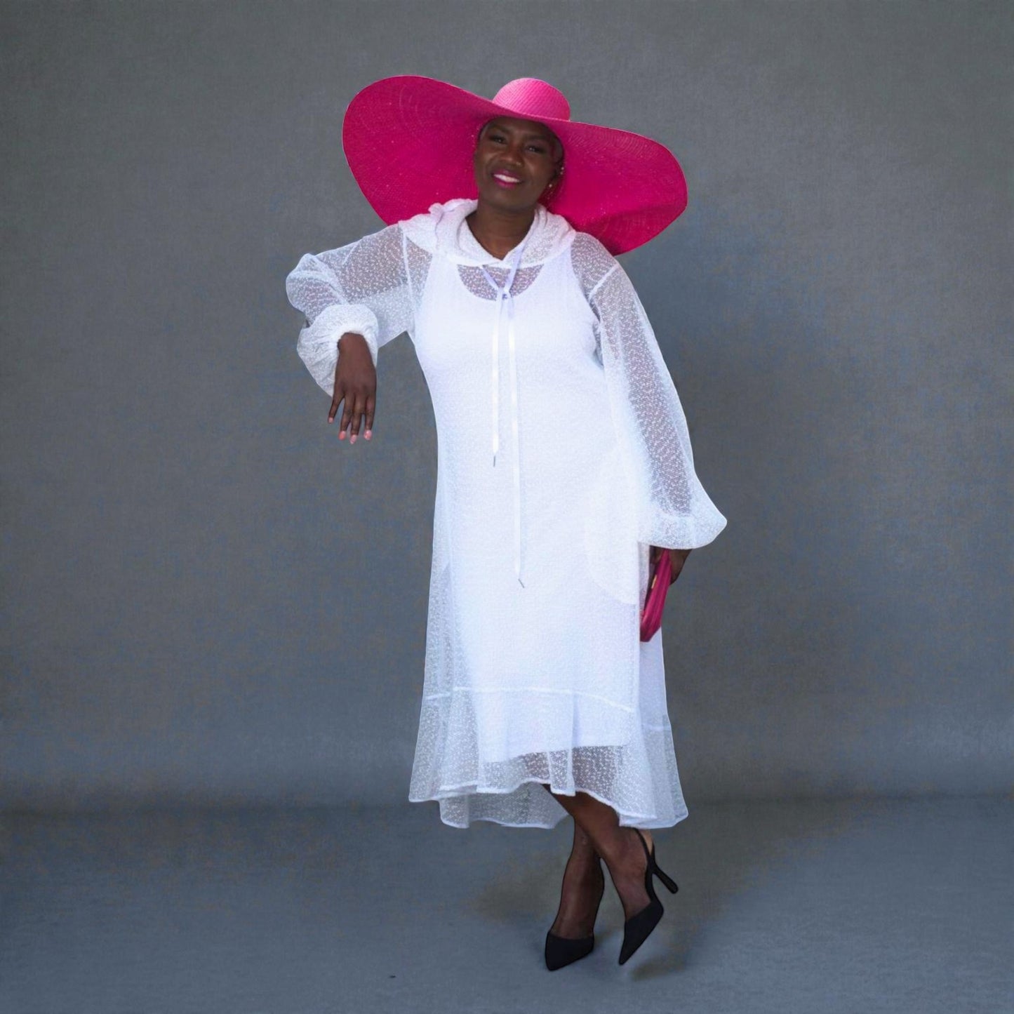 Women's Plus Size Aphrodite White Holiday Resort Dress with hoodie and white undergarment, paired with a pink sunhat, pink clutch, and black heels.