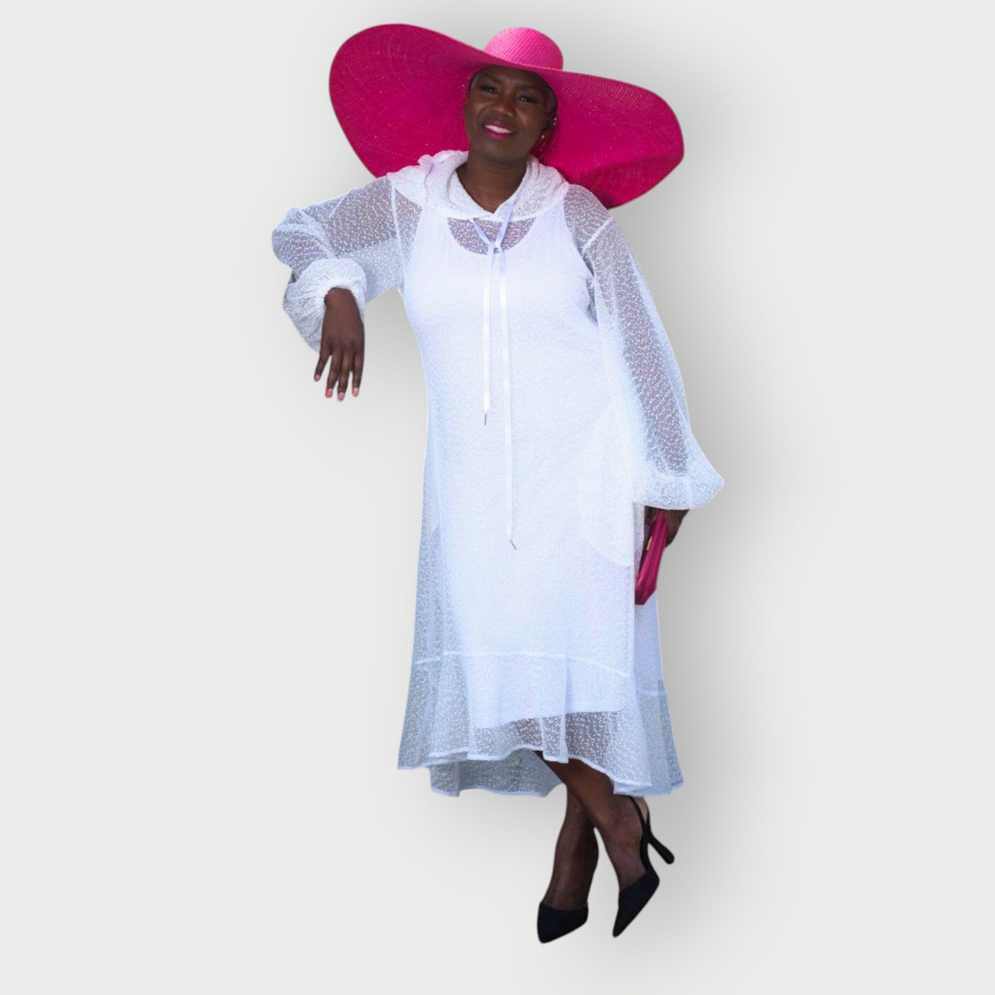 Women's Plus Size Aphrodite White Holiday Resort Dress with hoodie and white undergarment, paired with a pink sunhat, pink clutch, and black heels.