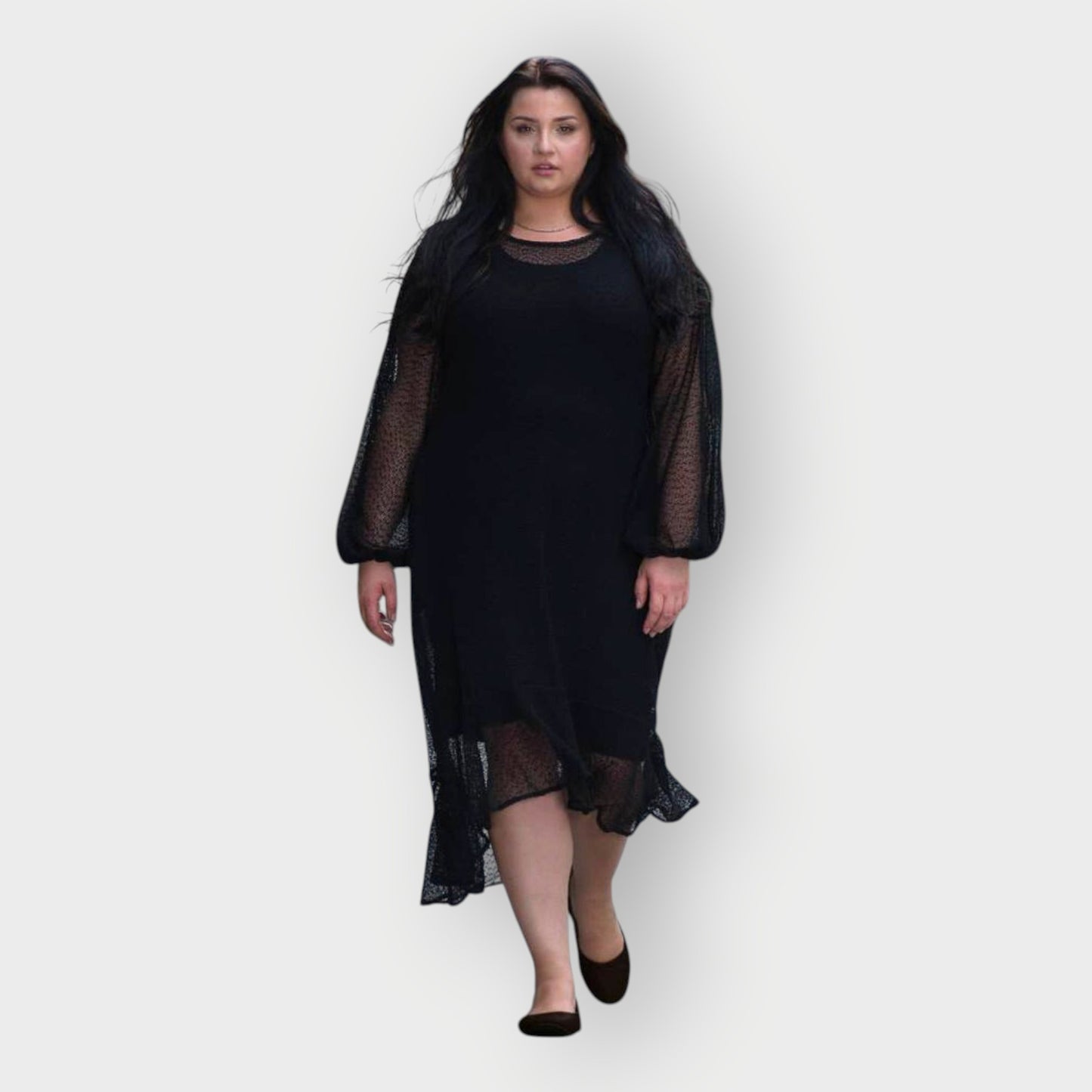 Woman wearing a black dress with sheer sleeves on a white background