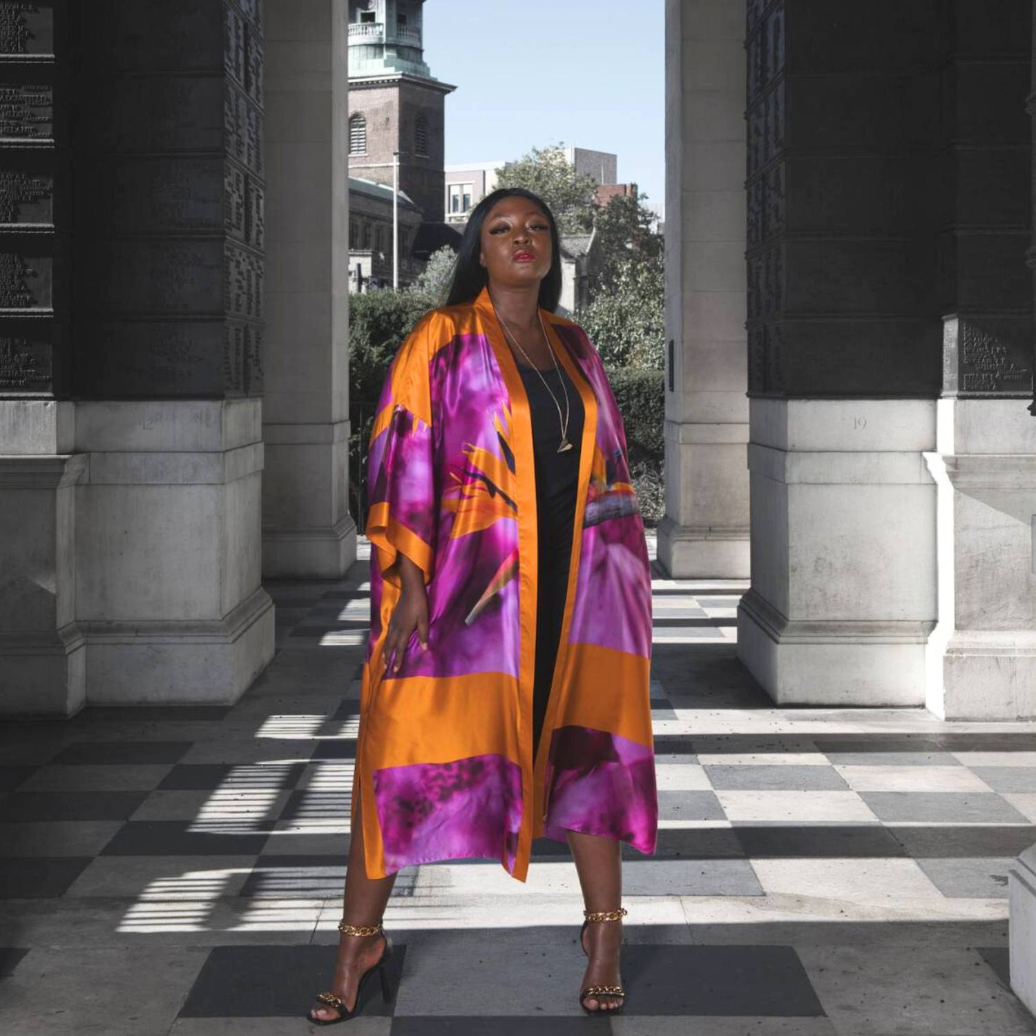 Women's Bird of Paradise Pink Purple Silk Kimono styled with the Boudicca Black Ruched Dress and gold chain heels for an elegant look..
