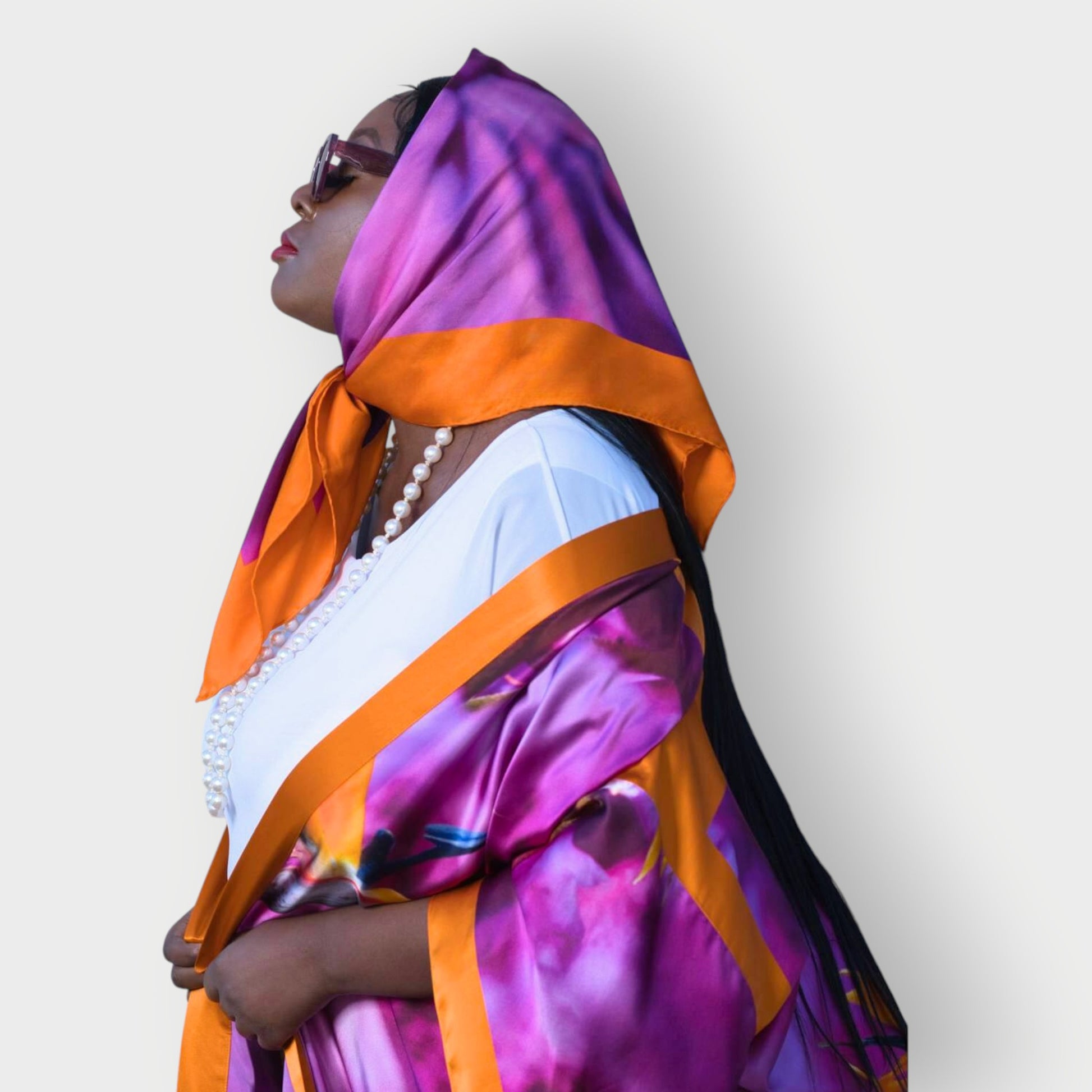 Silk scarf with Orange Bird of Paradise and Pink and Purple print styled as a headscarf, paired with a Pink and Purple Luxury Silk Kimono.White Background.