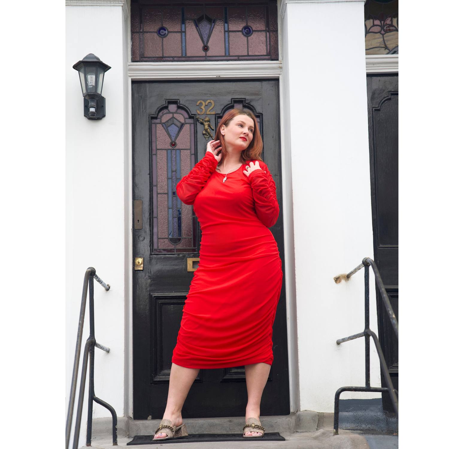 Women's Red Plus Size Boudicca Ruched Bodycon Midi Dress styled with silver jewelry by Veronique Designs and gold Kurt Geiger sandals.